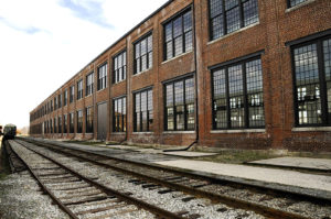 Image of a beautiful, red brick train station with several tracks off to the side of it.