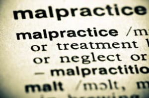 Image of a dictionary definition of malpractice, with the word malpractice showing, while all other words are blurred except "treatment" and "neglect".
